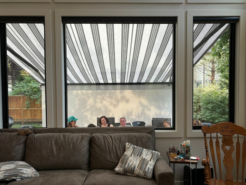 Hudson Valley family enjoying time together on their patio, shaded by a retractable awning.