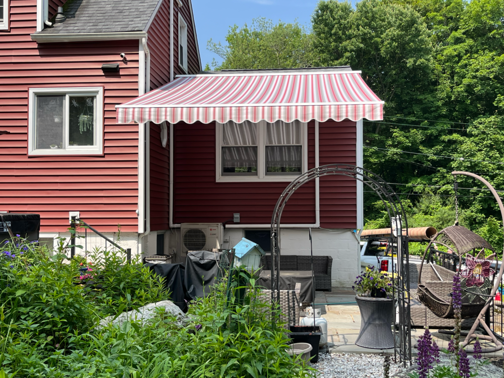 New Jersey home with an awning extended over a patio.